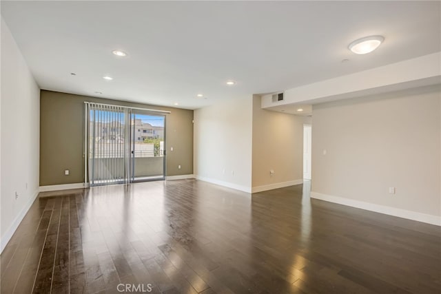 empty room with dark hardwood / wood-style flooring