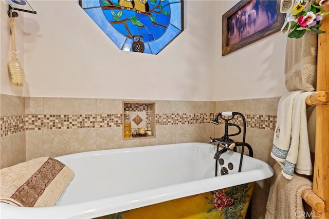 bathroom with a tub to relax in and tile walls