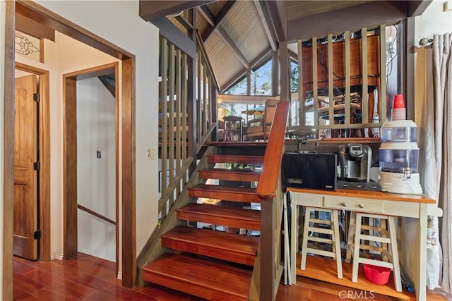 staircase with hardwood / wood-style flooring and lofted ceiling with beams