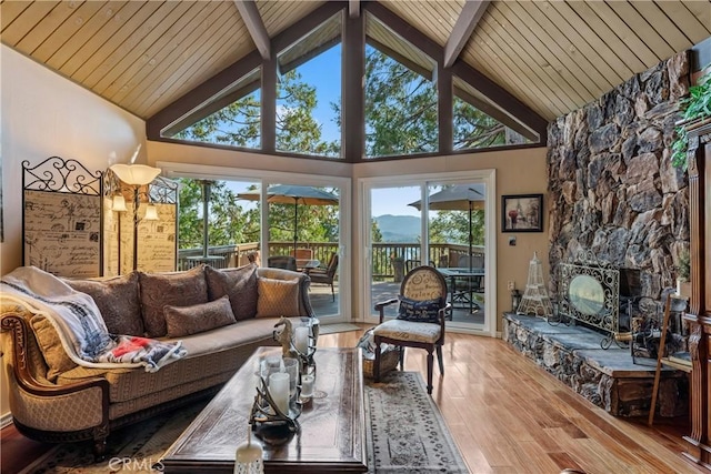 living room featuring beamed ceiling, a fireplace, high vaulted ceiling, and hardwood / wood-style flooring