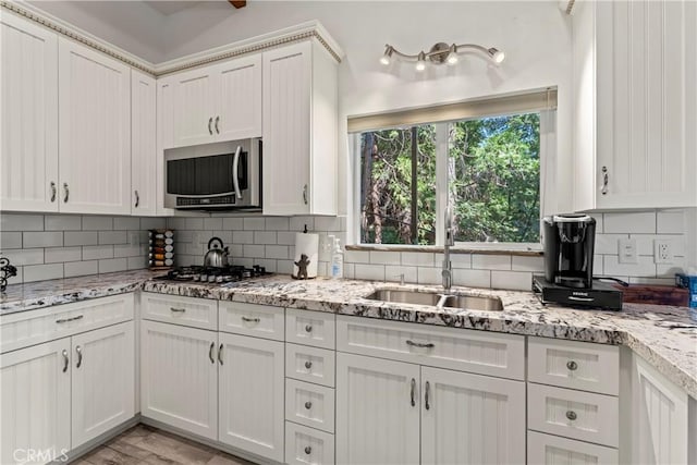 kitchen featuring sink, decorative backsplash, white cabinets, and appliances with stainless steel finishes