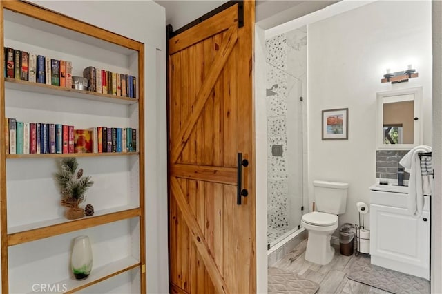 bathroom with hardwood / wood-style flooring, built in features, a shower with door, and toilet