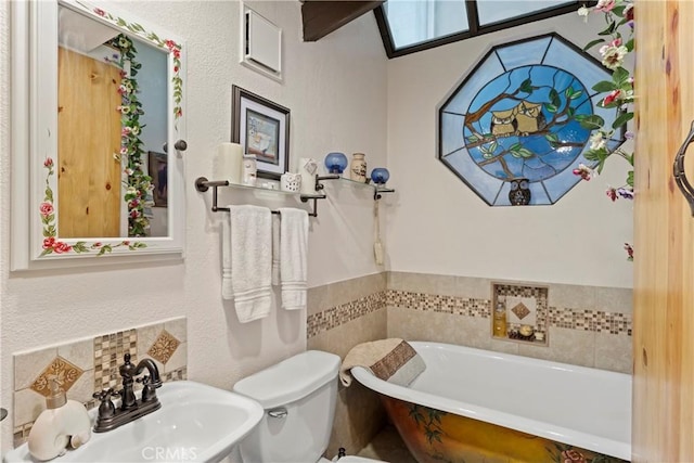 bathroom featuring sink, a bathtub, and toilet