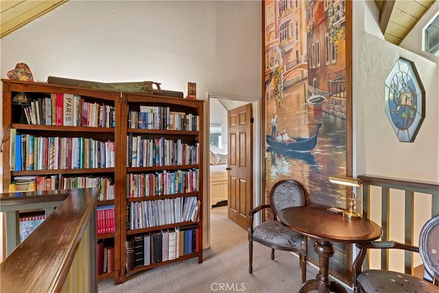 living area with lofted ceiling and light colored carpet