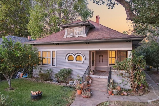 view of front of house with covered porch and a lawn