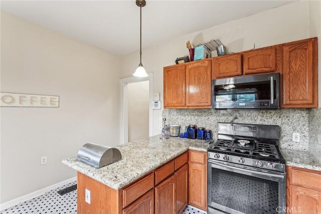 kitchen featuring backsplash, kitchen peninsula, decorative light fixtures, and appliances with stainless steel finishes