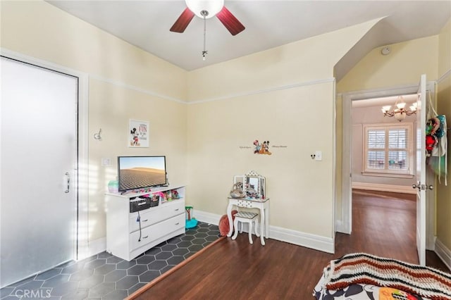 interior space featuring ceiling fan with notable chandelier and dark hardwood / wood-style floors