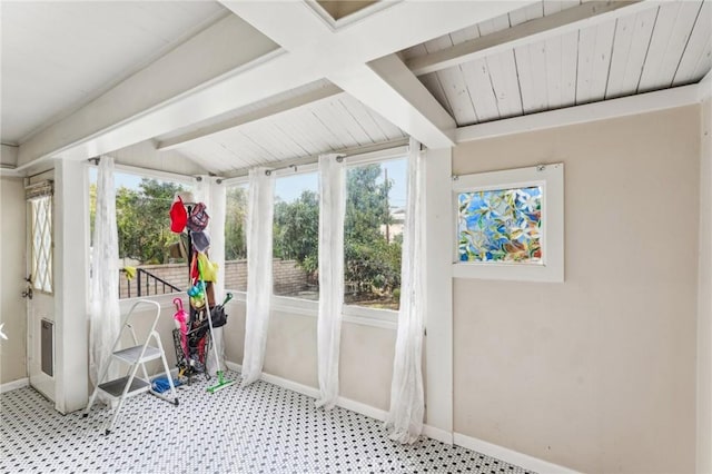 unfurnished sunroom featuring beam ceiling