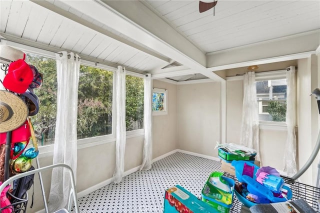 sunroom featuring ceiling fan, plenty of natural light, and beamed ceiling