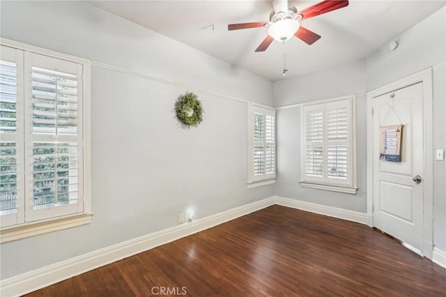 empty room with plenty of natural light, ceiling fan, and dark wood-type flooring