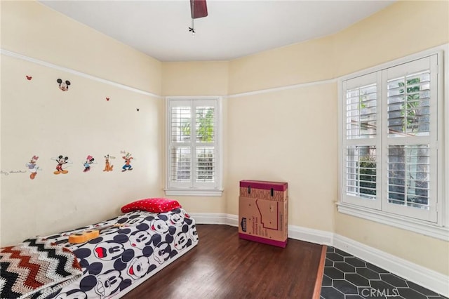 bedroom with multiple windows, ceiling fan, and dark hardwood / wood-style flooring