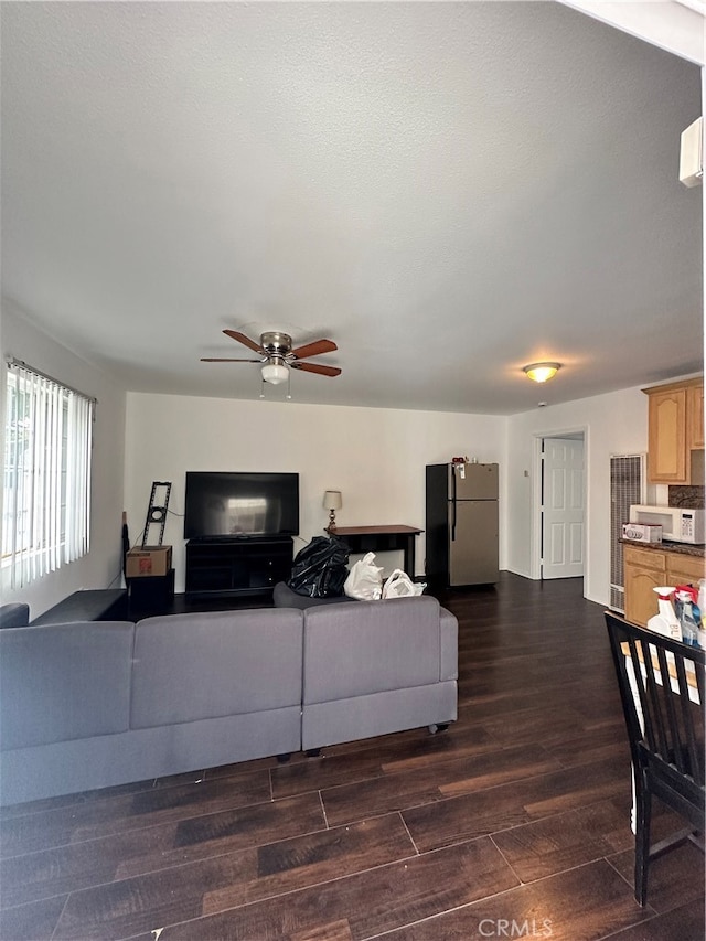 living room with ceiling fan and dark hardwood / wood-style flooring