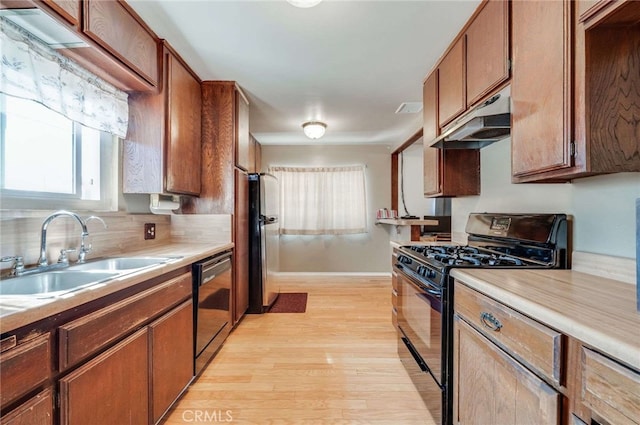 kitchen with sink, black appliances, and light wood-type flooring