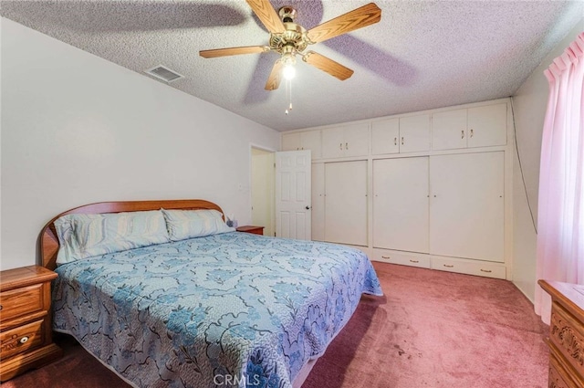 carpeted bedroom with ceiling fan, a textured ceiling, and a closet