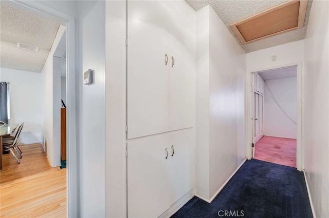 corridor featuring hardwood / wood-style floors and a textured ceiling