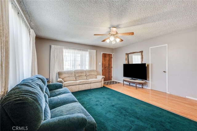 living room with hardwood / wood-style floors, ceiling fan, and a textured ceiling