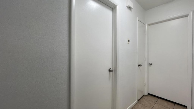 hall featuring light tile patterned flooring