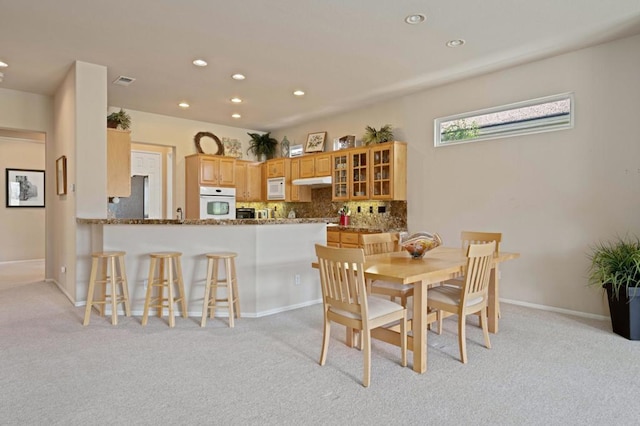 dining space featuring light carpet