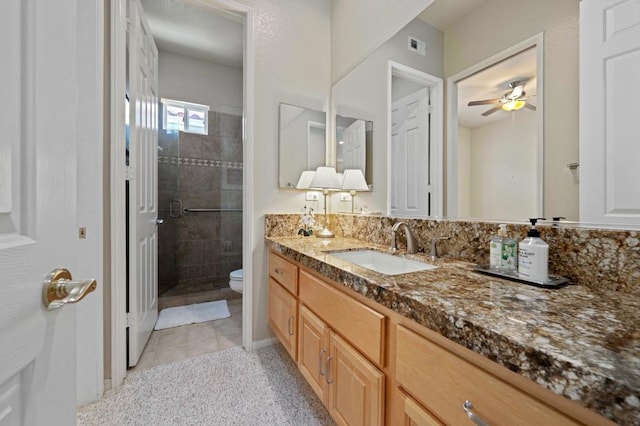 bathroom with an enclosed shower, vanity, ceiling fan, tile patterned flooring, and toilet