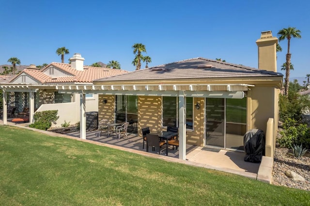 back of property with a lawn, a patio area, and a pergola