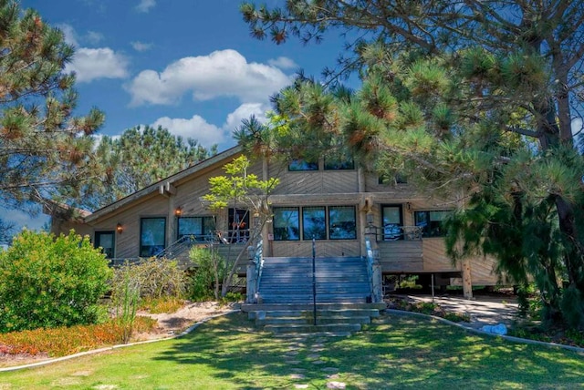 view of front of home featuring a front yard and a wooden deck