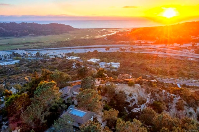 aerial view at dusk featuring a water view