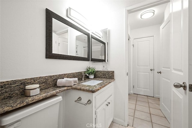 bathroom with tile patterned flooring, vanity, and toilet