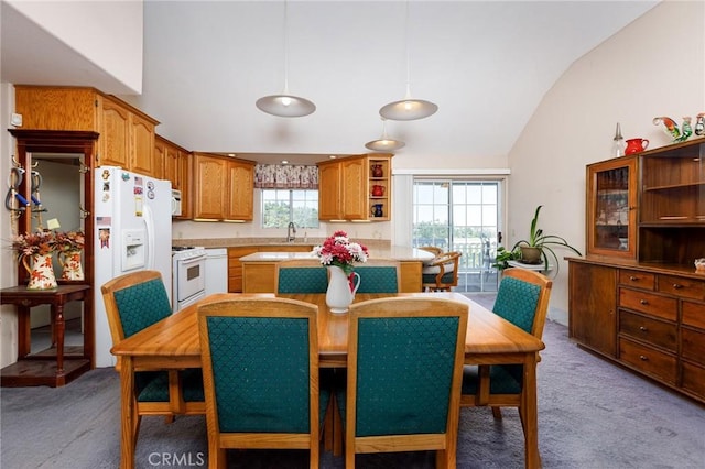 carpeted dining space featuring plenty of natural light, sink, and vaulted ceiling