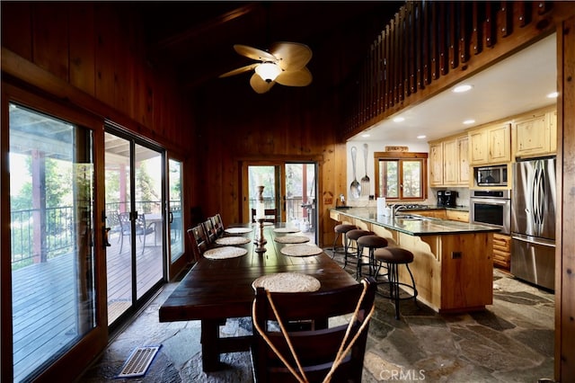 dining room with french doors, wooden walls, and a wealth of natural light