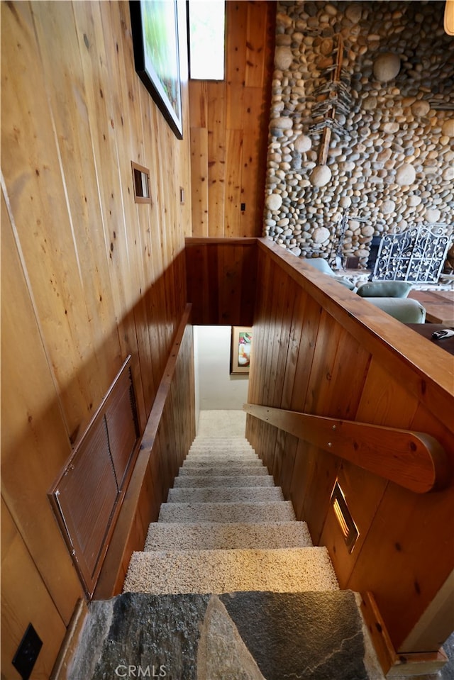 staircase featuring wooden walls