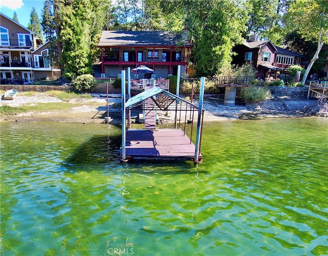 dock area with a water view and a balcony