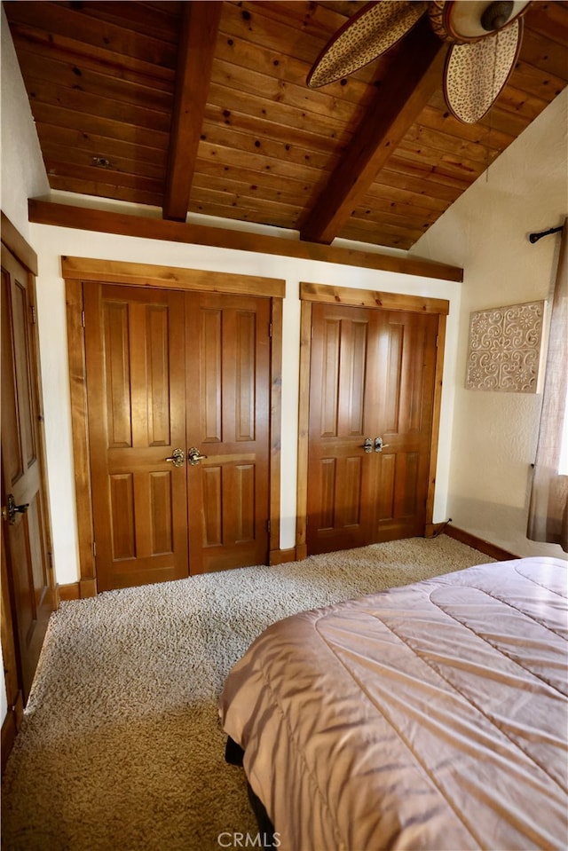 unfurnished bedroom featuring ceiling fan, lofted ceiling with beams, carpet, and wooden ceiling