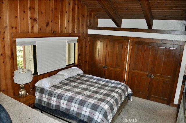 carpeted bedroom with wood walls, a closet, wooden ceiling, and vaulted ceiling with beams