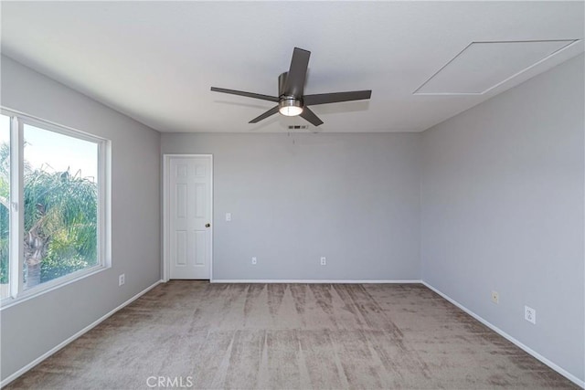 spare room featuring ceiling fan, light carpet, and a healthy amount of sunlight