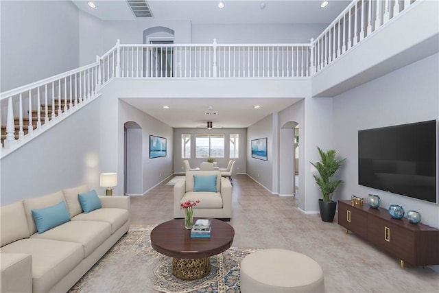 carpeted living room featuring a towering ceiling