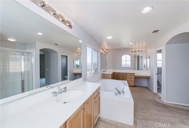 full bathroom featuring toilet, vanity, and separate shower and tub