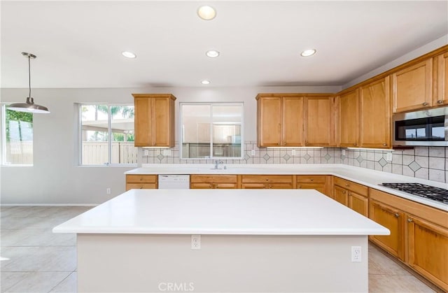 kitchen with decorative light fixtures, backsplash, a kitchen island, sink, and white appliances