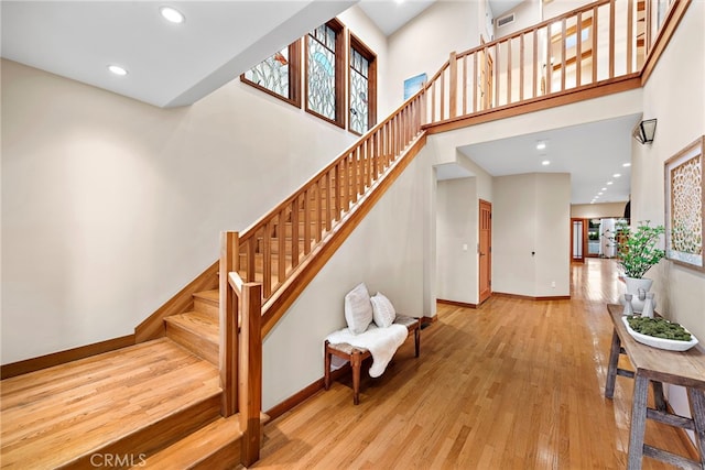 stairway featuring hardwood / wood-style flooring and a towering ceiling