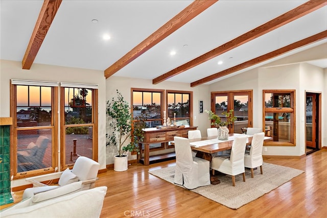 dining area featuring french doors, light wood-type flooring, lofted ceiling with beams, and plenty of natural light