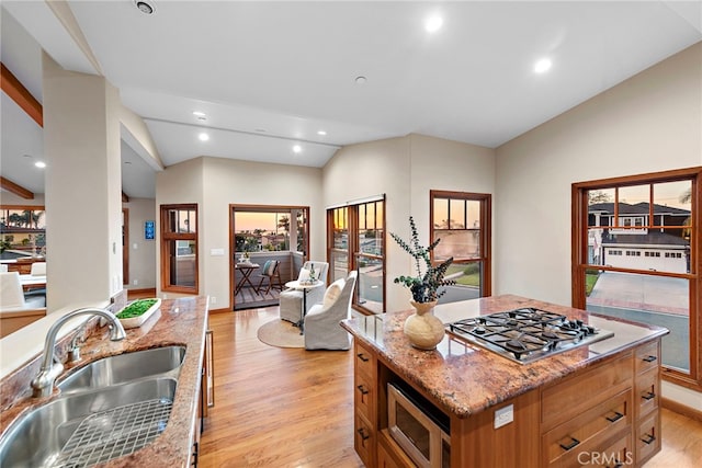 kitchen featuring lofted ceiling, sink, a kitchen island, stainless steel appliances, and light hardwood / wood-style floors