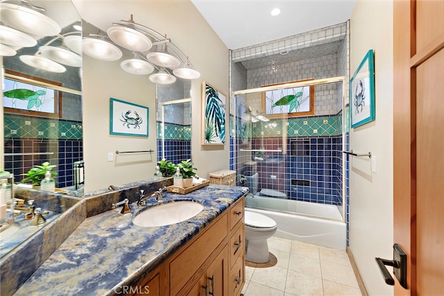 full bathroom featuring bath / shower combo with glass door, vanity, toilet, and tile patterned floors