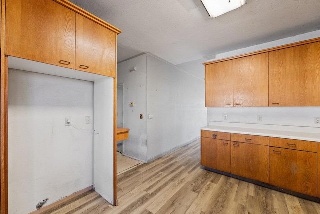 kitchen with light wood-type flooring and a textured ceiling