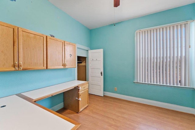 unfurnished office featuring light wood-type flooring and ceiling fan