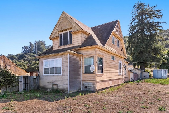 view of side of home with a shed