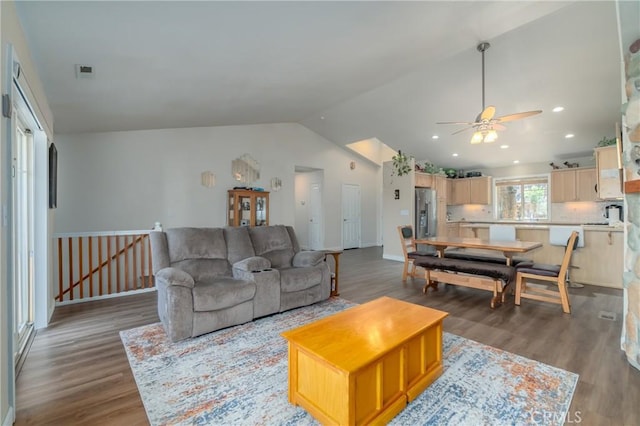 living room featuring ceiling fan, dark wood-type flooring, and vaulted ceiling