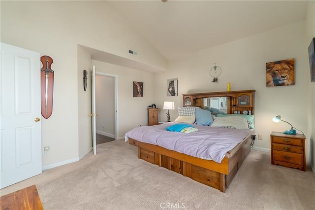 bedroom featuring light colored carpet and high vaulted ceiling