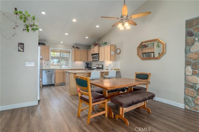 dining room featuring light wood-type flooring, high vaulted ceiling, and ceiling fan