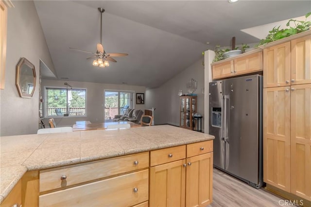 kitchen with ceiling fan, stainless steel fridge with ice dispenser, light hardwood / wood-style flooring, lofted ceiling, and light brown cabinetry