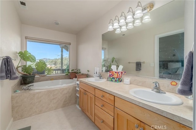 bathroom with tiled tub and vanity