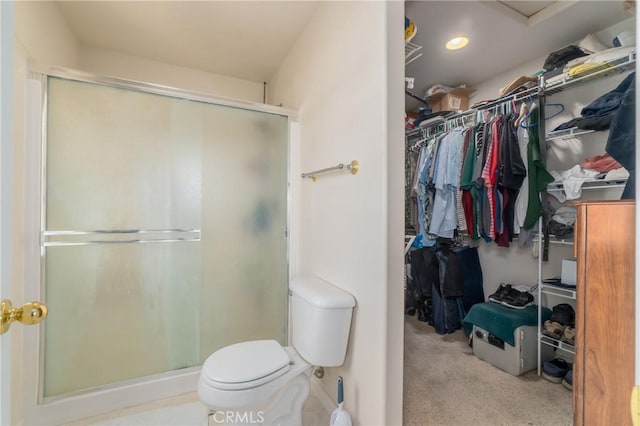 bathroom with a shower with door and toilet